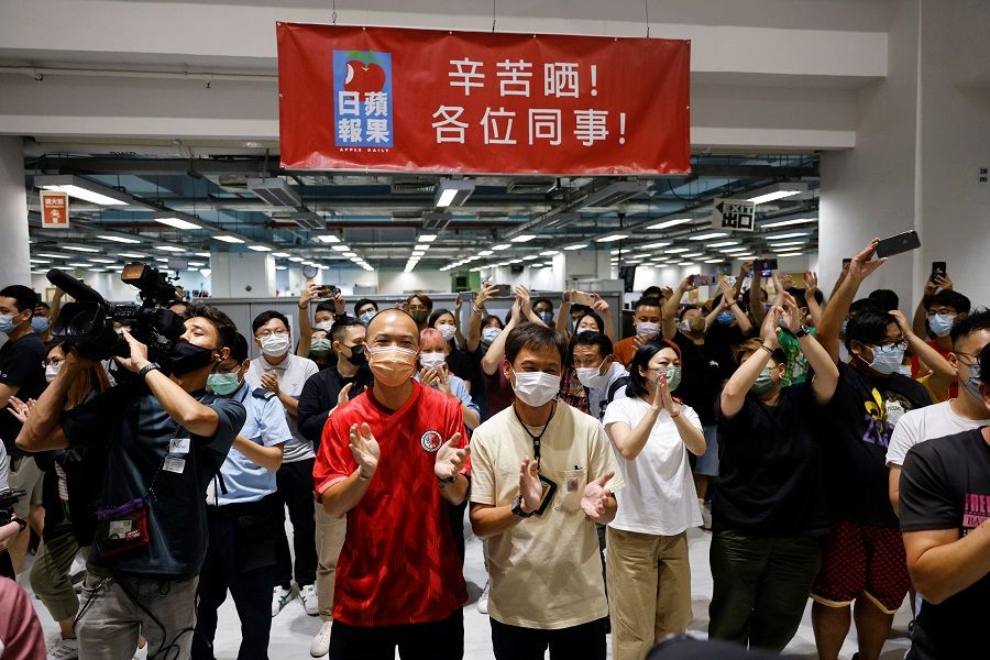 Staff members of Apple Daily and its publisher Next Digital react on the day of the newspaper's final edition in Hong Kong, China, 23 June 2021. (Tyrone Siu/Reuters)