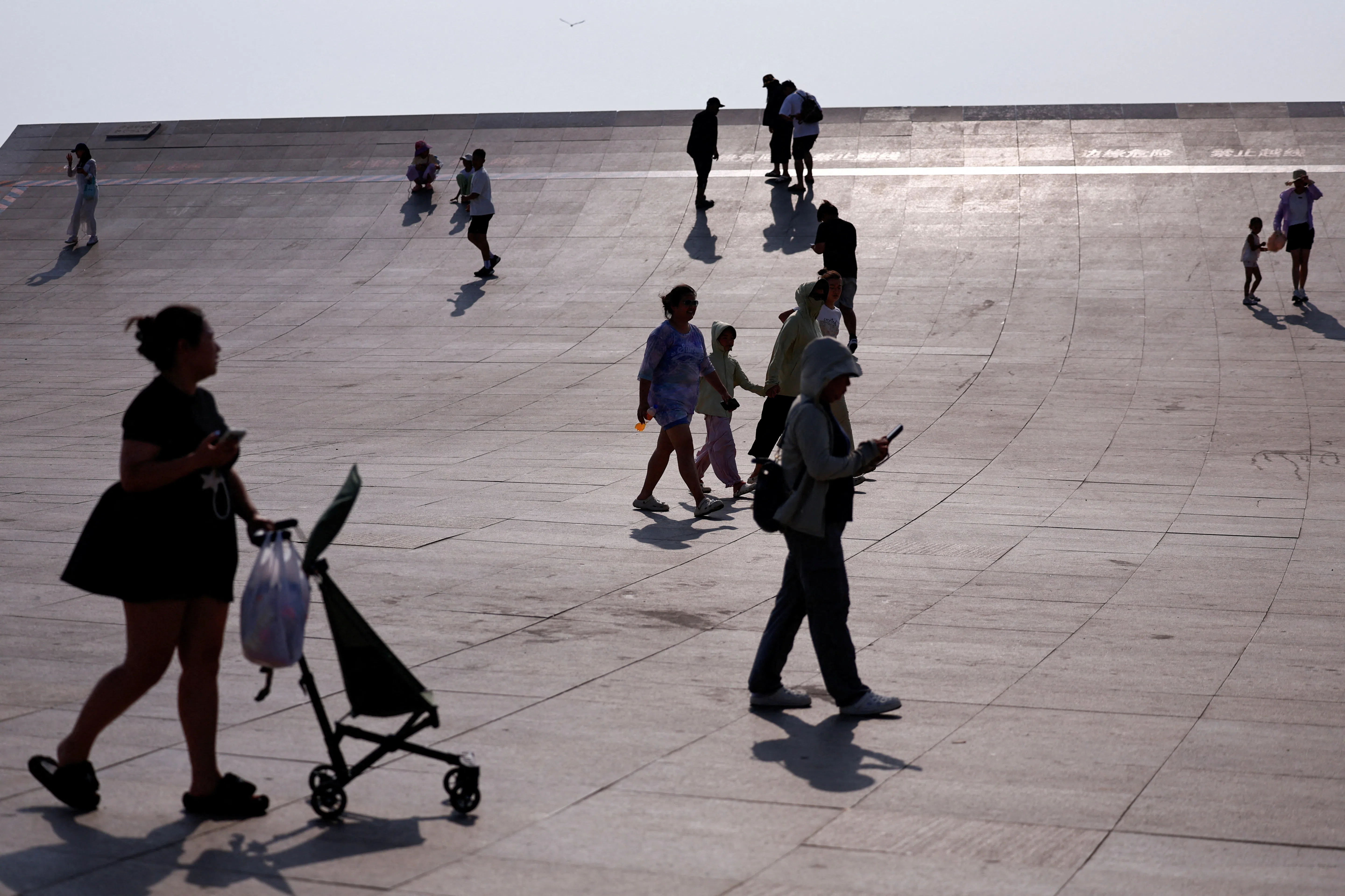 People walk at Xinghai Square in Dalian, Liaoning province, China, on 7 August 2026.