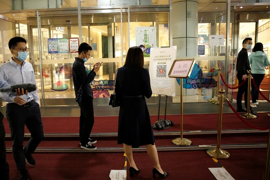 People scan a QR code to check their health before entering the Seasons Place shopping mall at the Beijing Financial Street, in Beijing, China, 23 September 2020. (Tingshu Wang/Reuters)