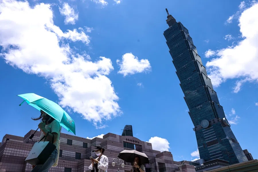 People use umbrellas to shelter from the sun as they walk along a street on a hot day in Taipei on 2 July 2025. (I-Hwa Cheng/AFP)