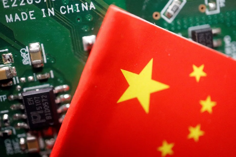 A Chinese flag is displayed next to a "Made in China" sign seen on a printed circuit board with semiconductor chips, in this illustration picture taken 17 February 2023. (Florence Lo/Illustration/File Photo/Reuters)