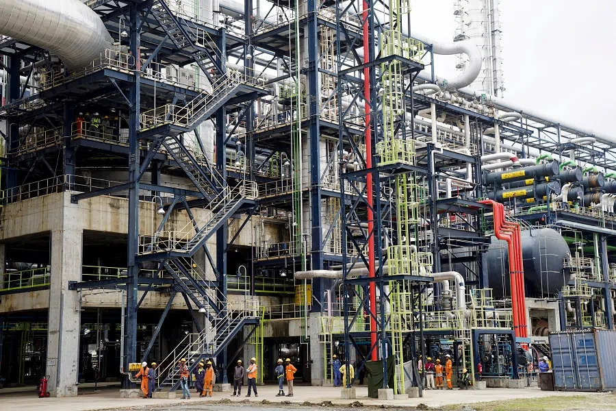 Workers stand in front of the Mild Hydrocracking Unit (MHC) at the Dangote Petroleum Refinery in Lagos, Nigeria, on 20 July 2024. (Marvellous Durowaiye/Reuters)