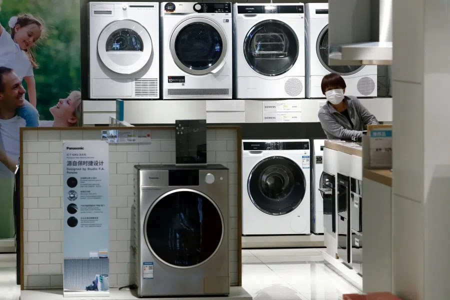 A woman wearing a protective mask looks at products at a home appliances retailer, following the Covid-19 outbreak, in Beijing, China, on 25 March 2020. (Thomas Peter/File Photo/Reuters)