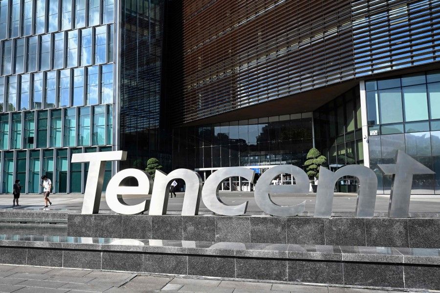 This photo taken on 10 July 2022 shows people walking past the Tencent headquarters in Shenzhen in China's southern Guangdong province. Tencent has moved into Saudi Arabia, partnering with telecom operator Mobily. (Jade Gao/AFP)