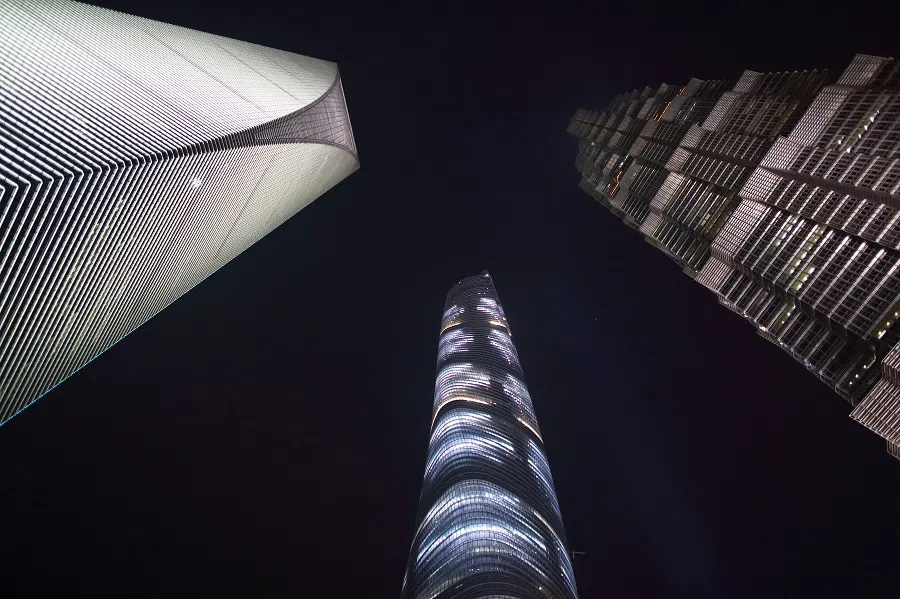 The Shanghai World Financial Center (left), the Shanghai Tower (centre), and the Jin Mao Tower stand illuminated at night in the Lujiazui district of Shanghai, China, 25 April 2015. (Tomohiro Ohsumi/Bloomberg)