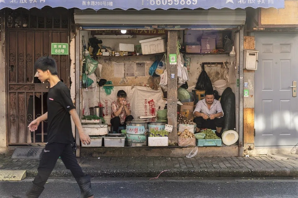Vendors sell vegetables at a stall in an older neighborhood in Shanghai, China, on 30 August 2021. (Qilai Shen/Bloomberg)