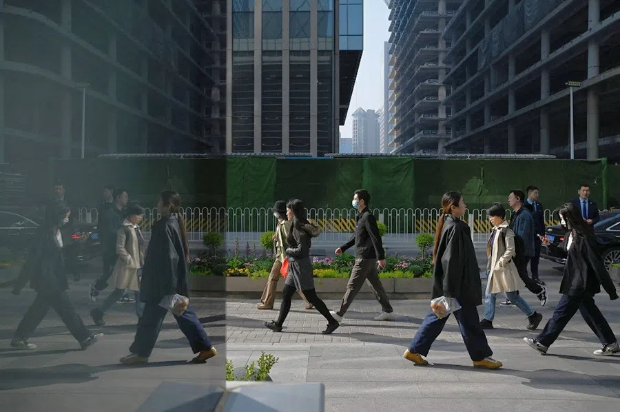 Office workers walk to their offices in Beijing’s central business district on 10 April 2025. (Greg Baker/AFP)