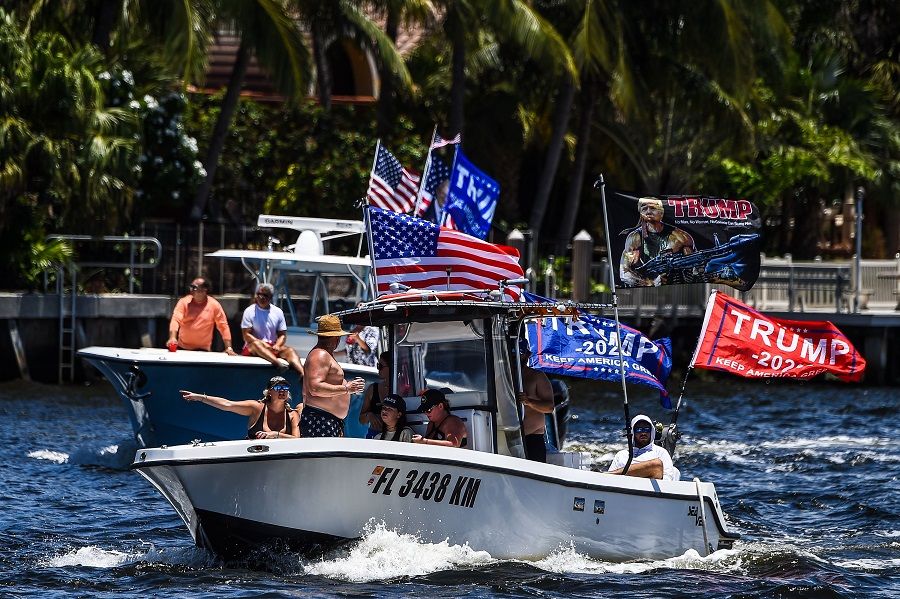Supporters of US President Donald Trump wave flags as they participate in a boat rally to celebrate Donald Trump's birthday in Fort Lauderdale, Florida on 14 June 2020. (Chandan Khanna/AFP)