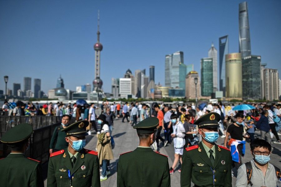 People visit the promenade on the Bund along the Huangpu River, 1 May 2021, Shanghai, China. (Hector Retamal/AFP)