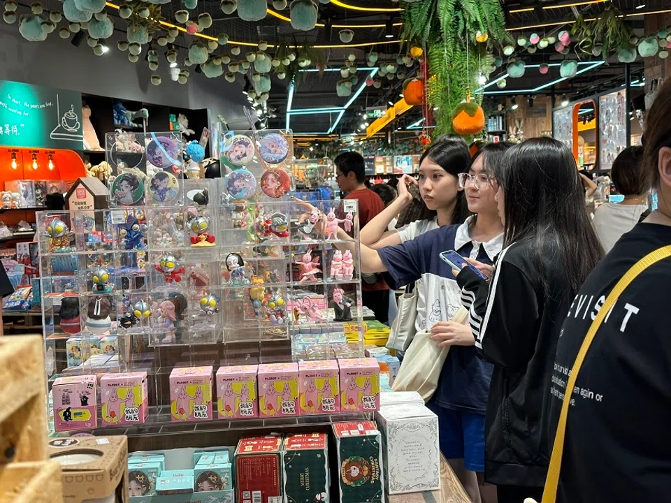 Youths looking at a variety of blind boxes.