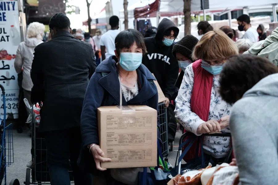 People receive food outside of a Brooklyn mosque and cultural center on 14 May 2021 in New York City. According to city estimates, 1.6 million New Yorkers are currently food insecure, compared to 1.2 million before the Covid-19 outbreak. (Spencer Platt/AFP)