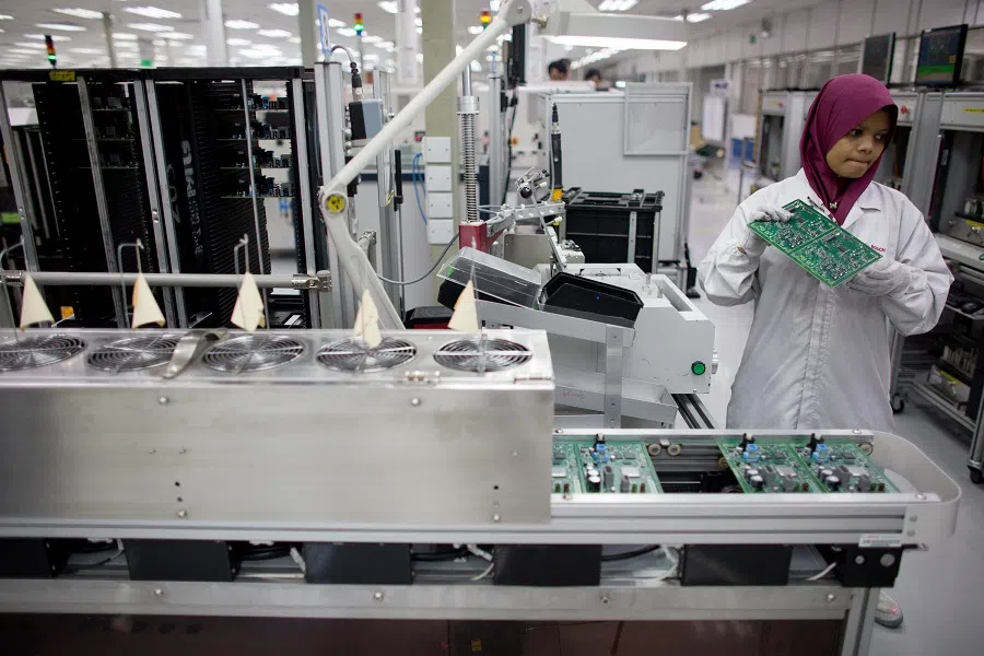 An employee holds a circuit board for the Jaguar Dual View Infotainment Control Module (ICM), produced by Robert Bosch GmbH for Jaguar Land Rover Plc on the production line at the Robert Bosch plant in the Bayan Lepas Industrial Zone on Penang Island, Malaysia, on 17 January 2013. (Bloomberg News)