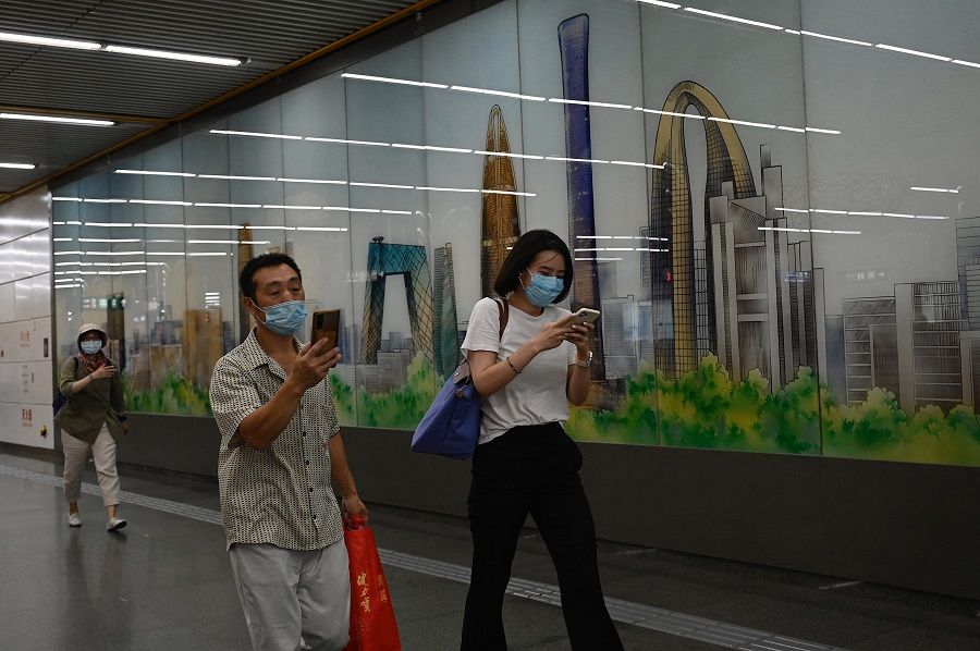 People walk past a mural depicting the central business district of Beijing at a subway station in Beijing, China, on 30 August 2022. (Jade Gao/AFP)