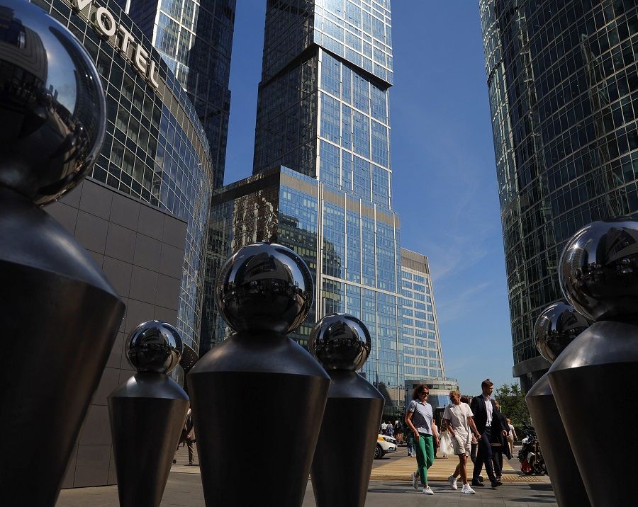 People walk next to skyscrapers at Moscow International Business Center, also known as Moscow-City, in Moscow, Russia, 12 August 2022. (Evgenia Novozhenina/Reuters)