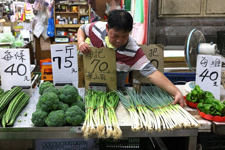 A man organises vegetables at his market stall in Taipei, Taiwan, 4 August 2022. (Ann Wang/Reuters)