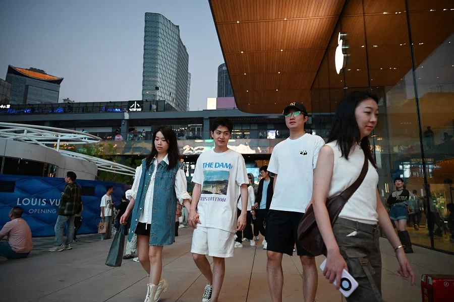 People walk in a shopping mall in Beijing, China, on 16 September 2024. (Greg Baker/AFP)