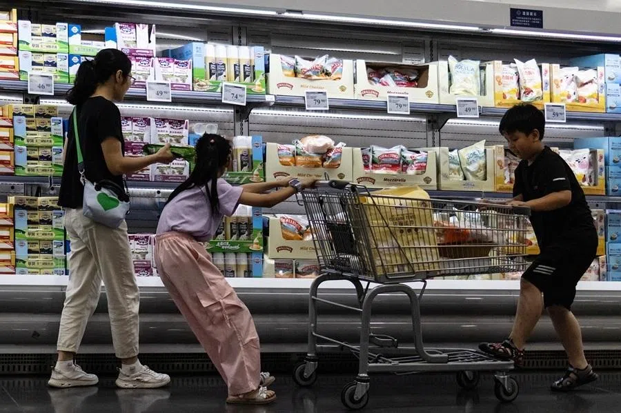 A woman and two children shop in front of a refrigerated cheese shelf at a supermarket in Beijing, China, on 10 July 2026.