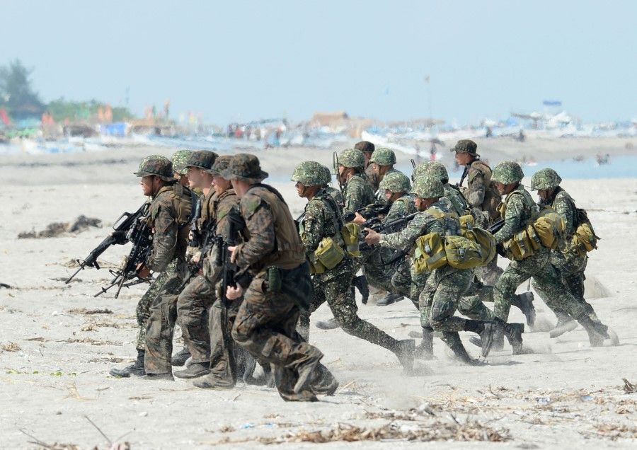 This file photo taken on May 9, 2014 shows Philippine and US Marines taking positions during a beach assault exercise facing the South China Sea in San Antonio, Zambales province. The Philippines told the US on February 11, 2020 it was quitting a pact key to their historical military alliance, which triggers a six-month countdown to the deal's termination, Manila said. (Ted Aljibe/AFP)
