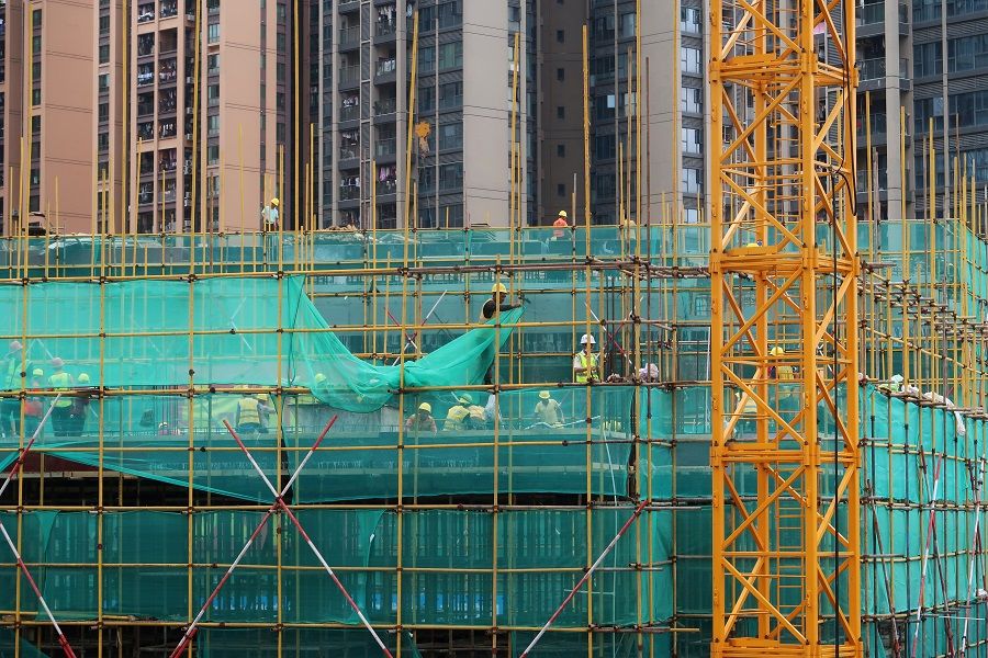 Workers are seen on scaffoldings of a construction site near residential buildings in Shenzhen, Guangdong province, China, 17 May 2020. (Martin Pollard/File Photo/Reuters)