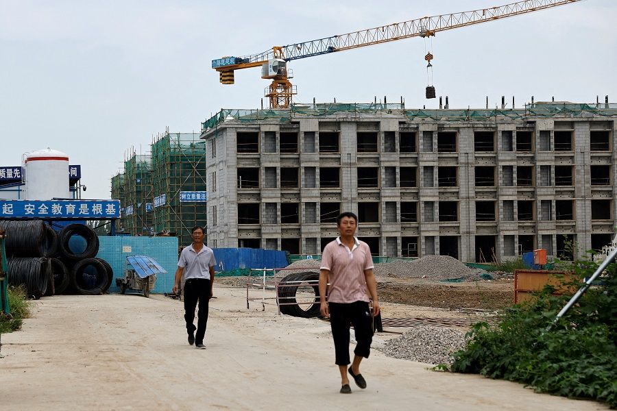 Workers walk out of a construction site of residential buildings in Tianjin, China, on 18 August 2023. (Tingshu Wang/Reuters)