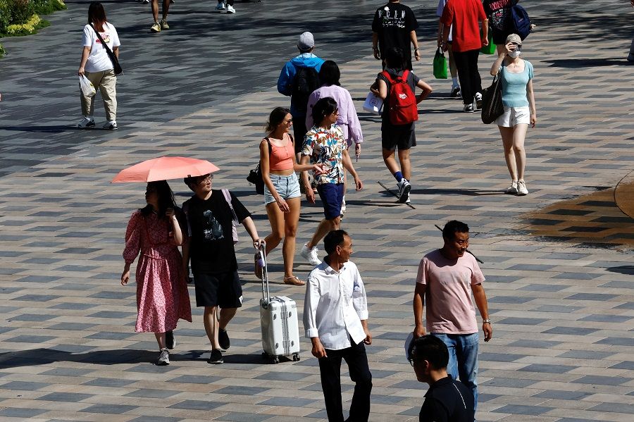 People walk at a shopping area in Beijing, China, 22 June 2023. (Tingshu WangReuters)