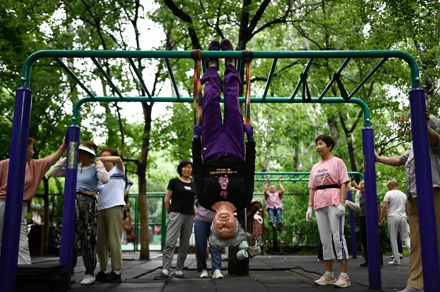 An elderly woman exercises at a park in Beijing on 19 June 2025. (Wang Zhao/AFP)