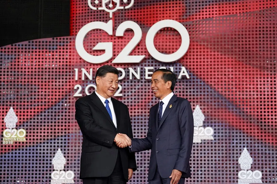 Chinese President Xi Jinping (left) shakes hands with Indonesian President Joko Widodo as he arrives for the G20 summit in Nusa Dua, on the Indonesian resort island of Bali on 15 November 2022. (Kevin Lamarque/Pool/AFP)