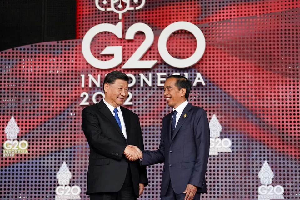 Chinese President Xi Jinping (left) shakes hands with Indonesian President Joko Widodo as he arrives for the G20 summit in Nusa Dua, on the Indonesian resort island of Bali on 15 November 2022. (Kevin Lamarque/Pool/AFP)