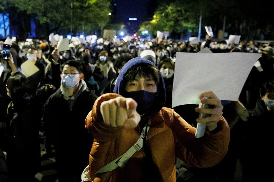 People hold white sheets of paper in protest over Covid-19 restrictions, after a vigil for the victims of a fire in Urumqi, as outbreaks of Covid-19 continue, in Beijing, China, 27 November 2022. (Thomas Peter/File Photo/Reuters)