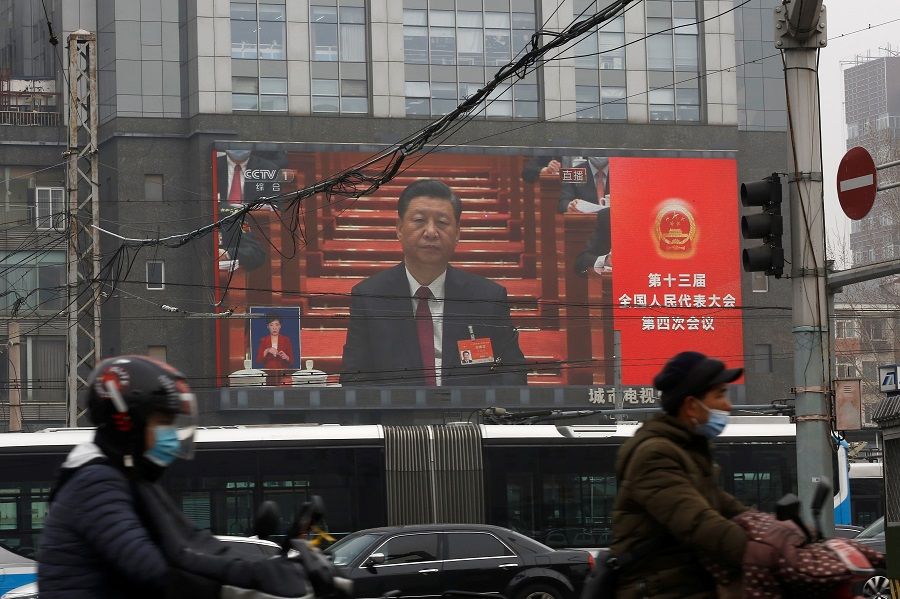 A giant screen shows Chinese President Xi Jinping attending the opening session of the National People's Congress (NPC) at the Great Hall of the People, in Beijing, China, 5 March 2021. (Tingshu Wang/Reuters)