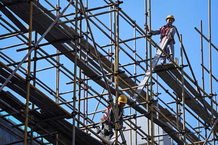 Workers are seen on a scaffold at a construction site in Beijing on 2 September 2022. (Jade Gao/AFP)