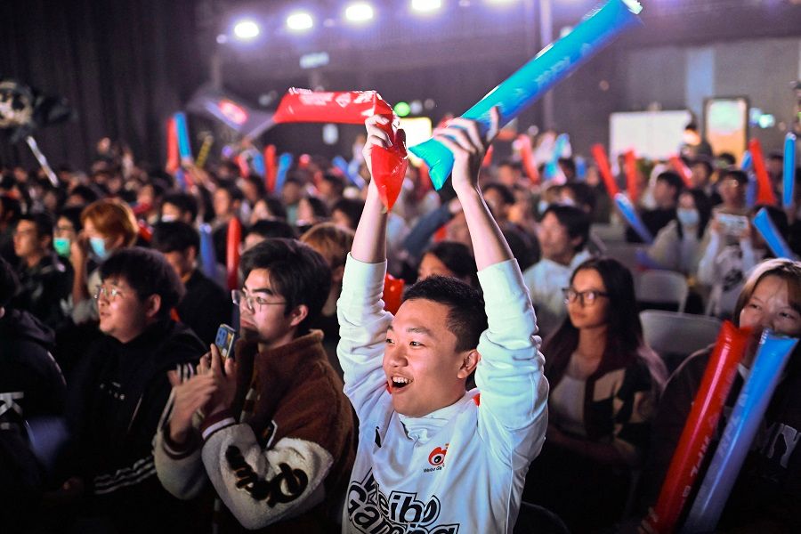 Gaming fans react as they watch a big screen showing the League of Legends World Championship 2023 final between South Korean's T1 and China's Weibo Gaming, at the Communication University of China in Beijing, China, on 19 November 2023. (Pedro Pardo/AFP)