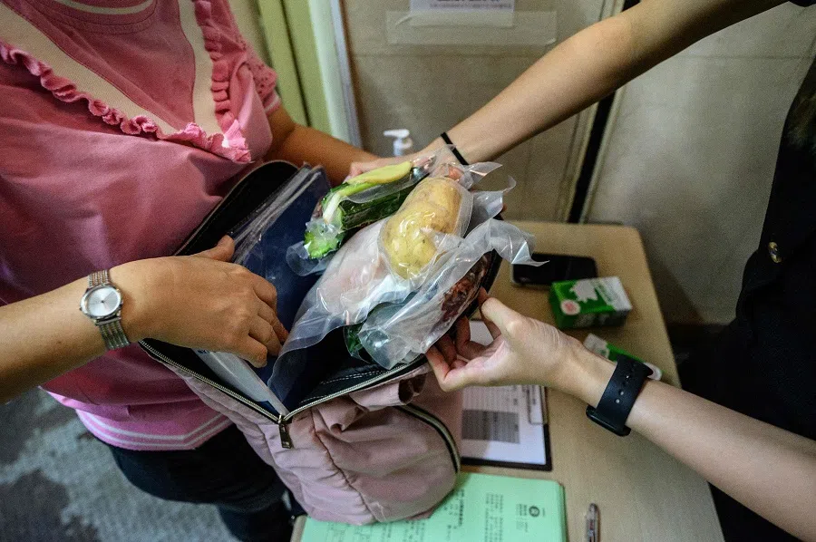 In this picture taken on 16 June 2021, twice-weekly food relief packages are collected by eligible recipients at the Concern for Grassroots' Livelihood Alliance charity group's centre in Hong Kong. (Anthony Wallace/AFP)