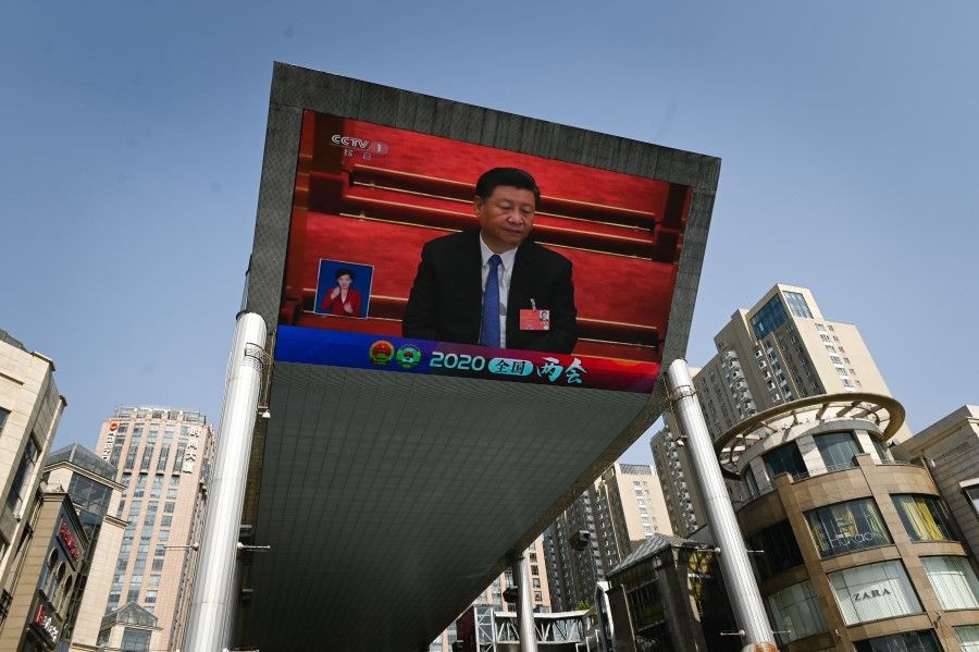 An outdoor screen shows live coverage of China's President Xi Jinping attending the closing session of the National People's Congress (NPC) in Beijing, 28 May 2020. (Wang Zhao/AFP)