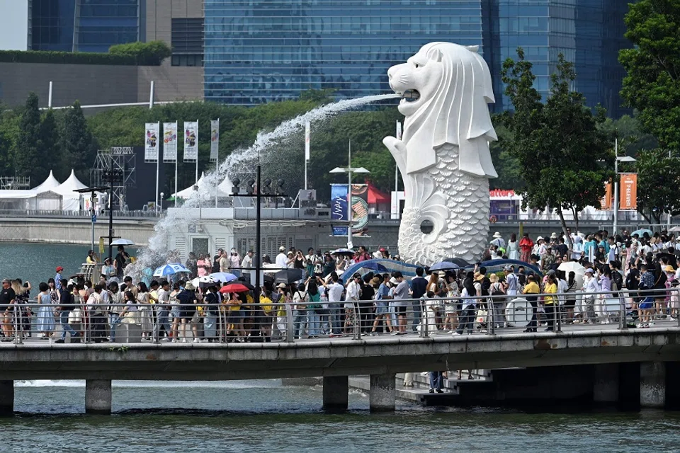 People gather next to the Merlion statue at the Marina Bay Waterfront Promenade in Singapore on 7 August 2024. (Roslan Rahman/AFP)