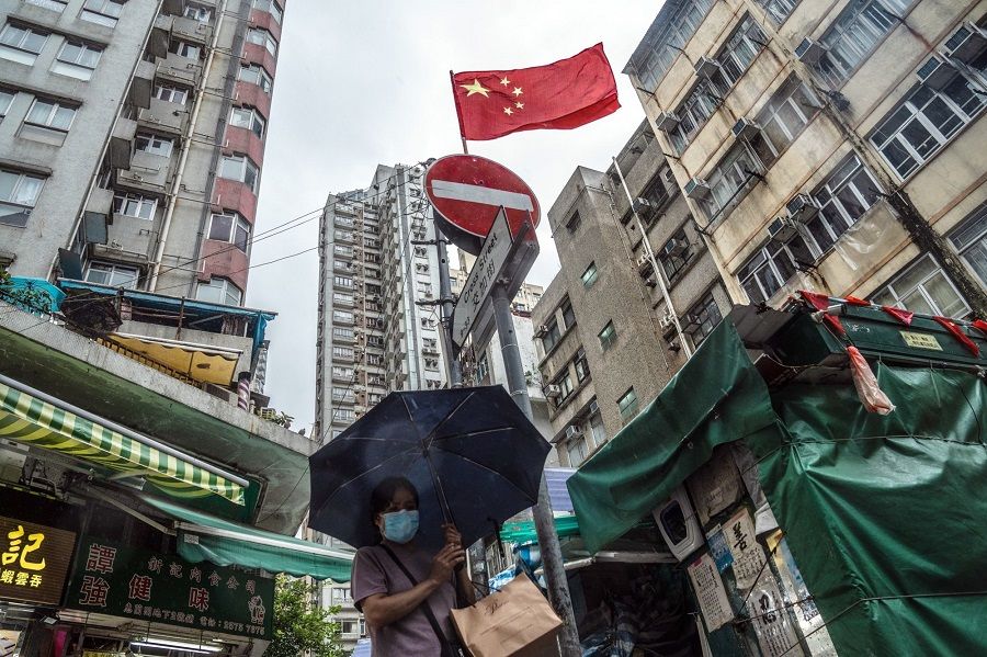 A pedestrian passes a Chinese flag on the 25th anniversary of Hong Kong's return to Chinese rule in Hong Kong, on 1 July 2022. (Lam Yik/Bloomberg)