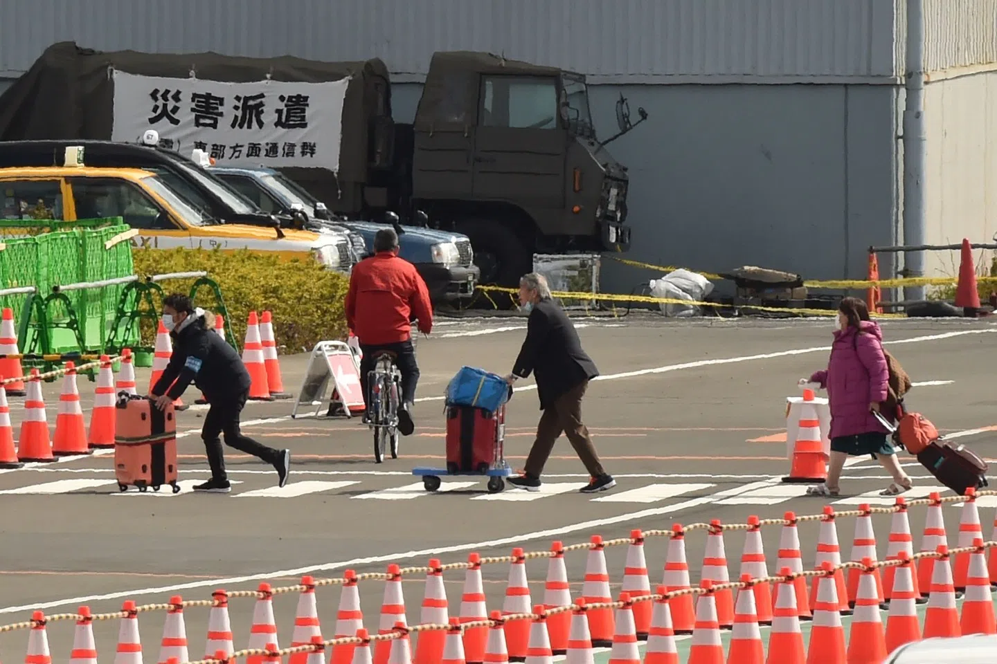 Passengers leave after disembarking from the Diamond Princess cruise ship in quarantine at the Daikoku Pier Cruise Terminal in Yokohama on 19 February 2020 after testing negative for the virus. (Kazuhiro Nogi/AFP)