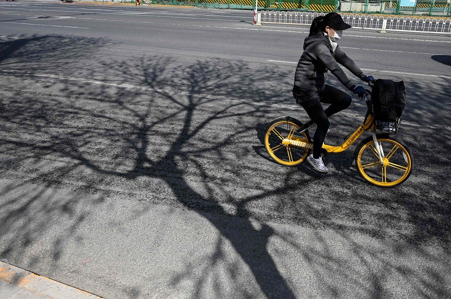 A woman rides a bicycle along a street in Beijing, China, on 6 April 2022. (Jade Gao/AFP)