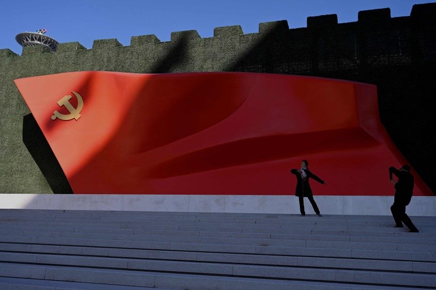 Visitors pose for a picture in front of a national flag sculpture at the Museum of the Communist Party of China in Beijing on 11 November 2021. (Noel Celis/AFP)