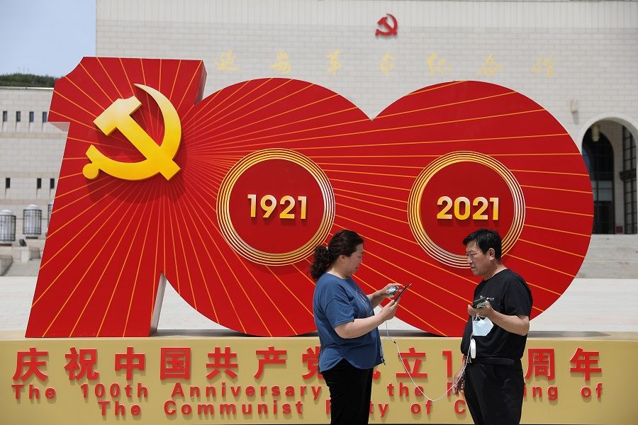 Visitors stand in front of an installation marking the 100th founding anniversary of the Communist Party of China at Yan'an Revolution Memorial Hall during a government-organised tour in Yan'an, Shaanxi province, China, 10 May 2021. (Tingshu Wang/Reuters)