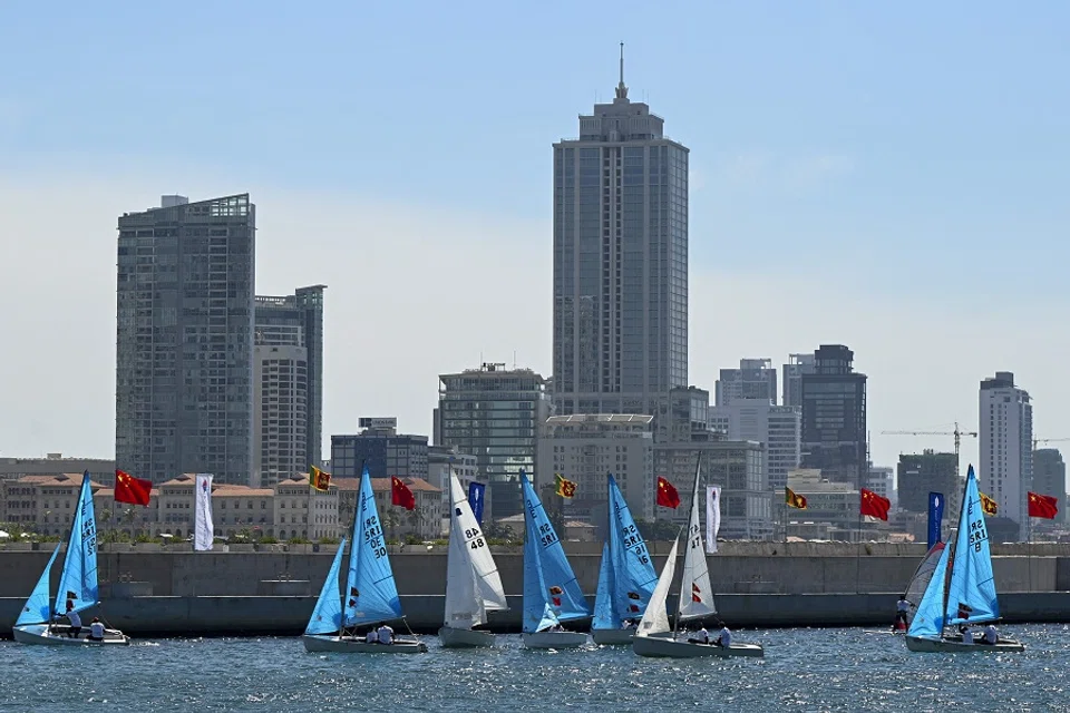 Chinese and Sri Lankan national flags flutter from poles at the Chinese-funded sea reclamation Port City project as sail boats compete in a sailing event attended by Chinese Foreign minister Wang Yi (not pictured) on the occasion of the 65th anniversary of diplomatic relations between the Sri Lanka and China at the Colombo Port city project, in Colombo, Sri Lanka, on 9 January 2022. (Ishara S. Kodikara/AFP)