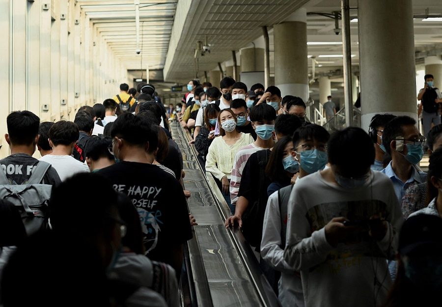 People ride escalators in and out of the subway in Beijing, China, on 9 August 2021. (Noel Celis/AFP)
