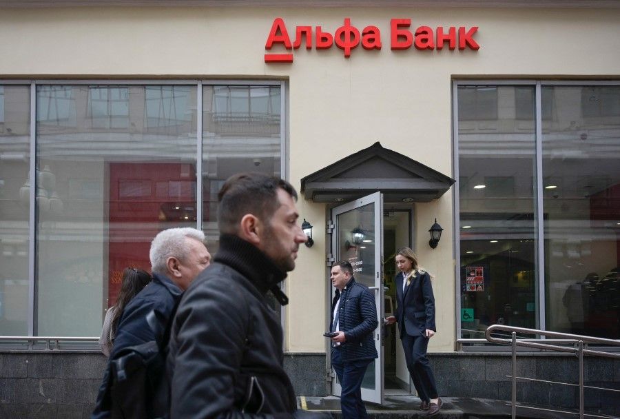 Pedestrians walk past the branch of Alfa Bank, Russia's largest private bank, in Moscow on 7 April 2022. (Natalia Kolesnikova/AFP)