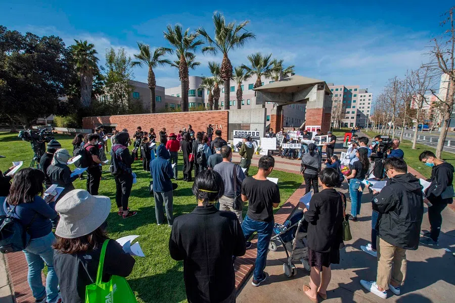 Chinese students and their supporters hold a memorial for Dr Li Wenliang outside the UCLA campus in Westwood, California, on 15 February 2020. (Mark Ralston/AFP)