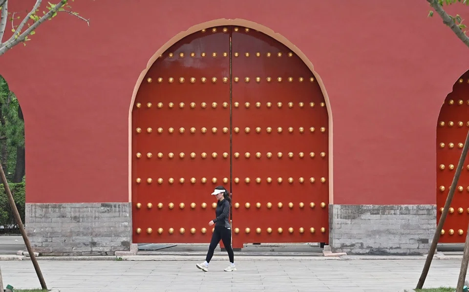 A woman walks along Ritan Park in Beijing, China, on 23 July 2024. (Adek Berry/AFP)