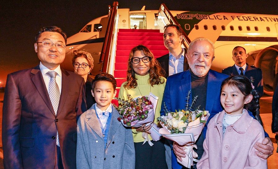 Brazil's President Luiz Inacio Lula da Silva and First Lady Rosangela "Janja" da Silva (both with flowers in hand) being greeted on arrival by Chinese Vice Minister of Foreign Affairs Xie Feng in Shanghai, China, 12 April 2023. (Ricardo Stuckert/Handout via Reuters)