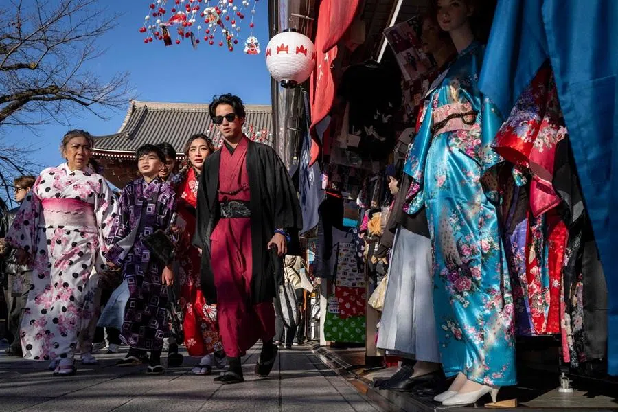People walk through the Nakamise Shopping Street at the Asakusa district in Tokyo on 8 January 2026. (Yuichi Yamazaki/AFP)