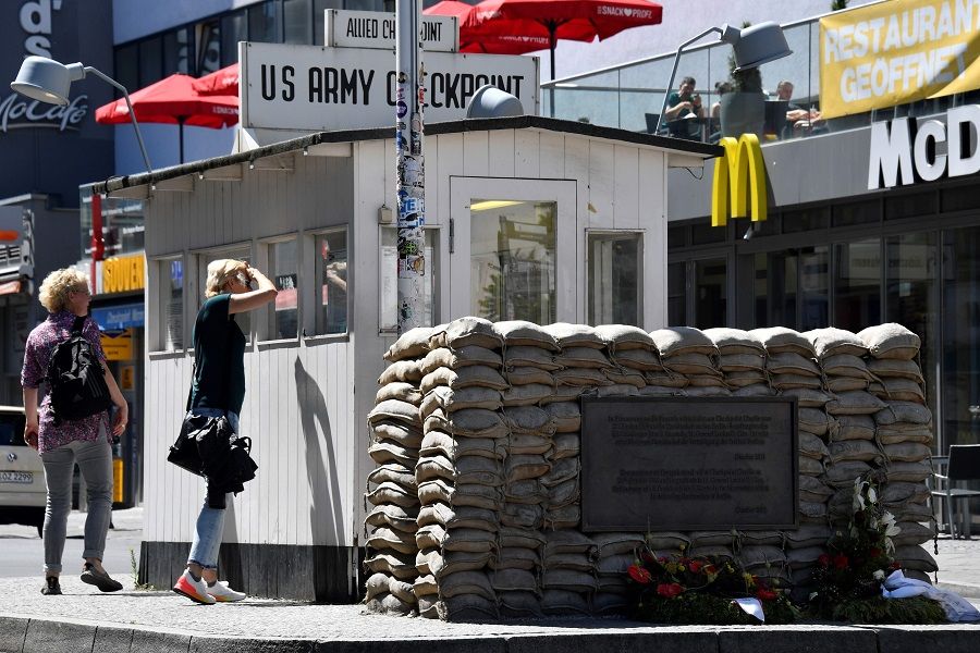 People visit Checkpoint Charlie landmark, a border crossing point between East and West Berlin during the Cold War, on 22 June 2020 in Berlin. (John Macdougall/AFP)
