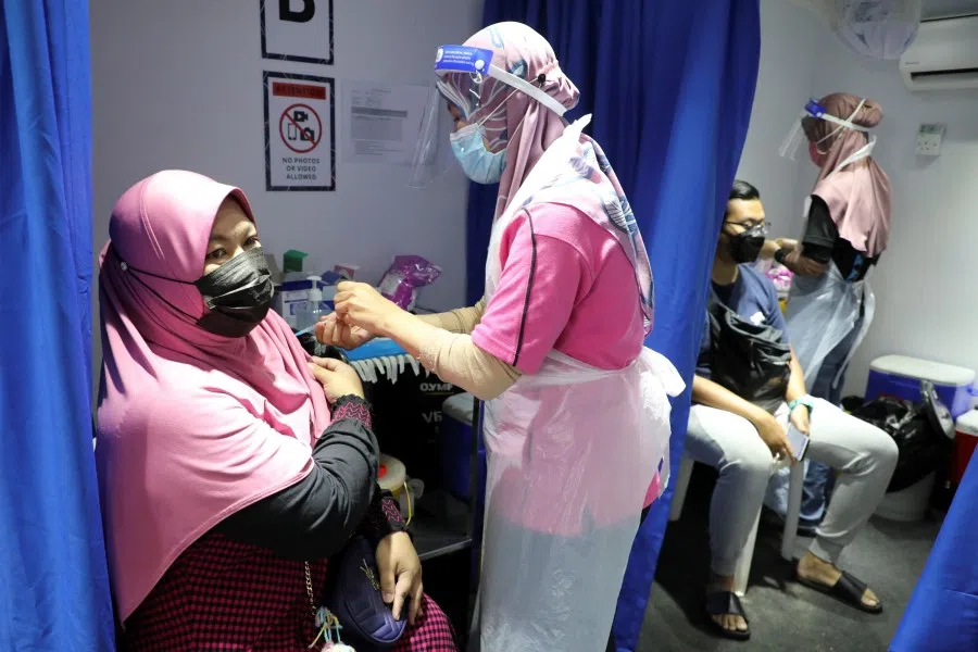 People receive doses of the Sinovac vaccine against the coronavirus disease (Covid-19) in a vaccination truck in Kuala Lumpur, Malaysia, on 12 July 2021. (Lim Huey Teng/Reuters)