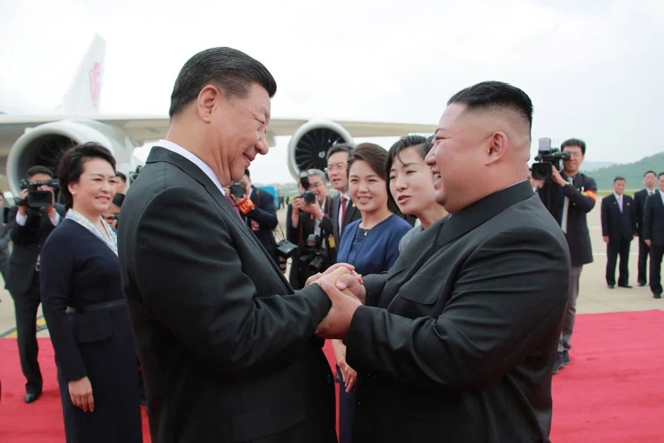 In this handout file photo taken and released by North Korea's official Korean Central News Agency (KCNA) on 21 June 2019 North Korean leader Kim Jong Un (right) shakes hands with Chinese President Xi Jinping upon his arrival at Pyongyang international airport in Pyongyang. (KCNA via KNS/AFP)